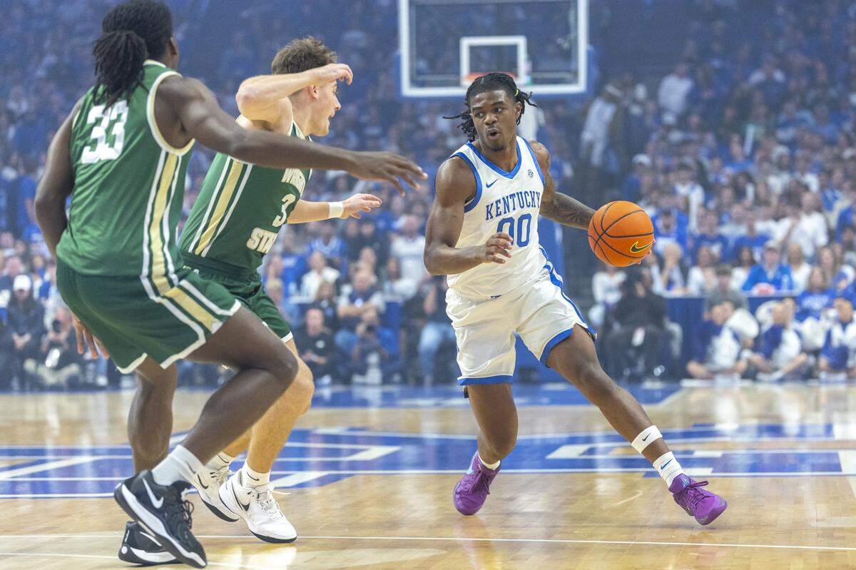 Kentucky guard Otega Oweh (00) looks to drive the ball around Wright State guard Alex Huibregtse (3) forward Michael Imariagbe (33) during Monday’s game at Rupp Arena.