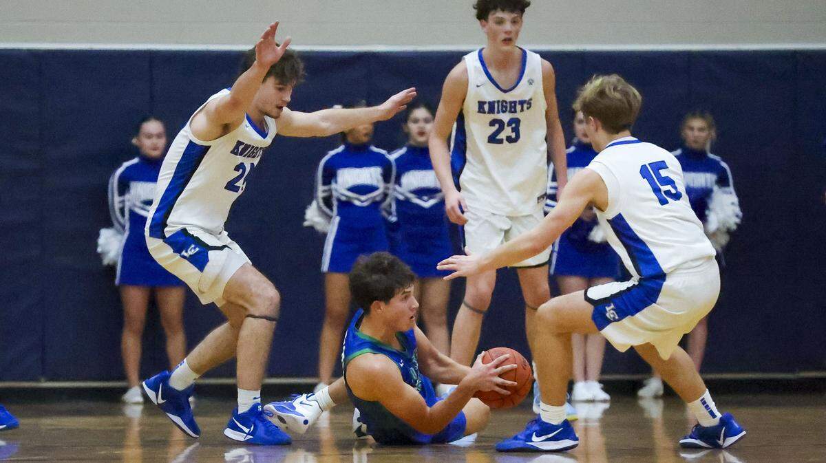 North Laurel's Reece Davidson (30) is surrounded by a swarm of Lexington Catholic defenders during the Knights win over North Laurel, Tuesday, Dec. 2, 2025 at Lexington Catholic High School in Lexington, Ky.