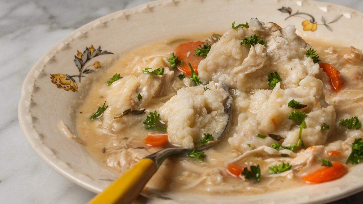 Biscuit-like dumplings float like clouds atop a simple stew of large pieces of tender chicken studded with bright orange carrots and flecks of herbs in this dish of Sheri’s Shortcut Chicken Stew With Fluffy Dumplings.