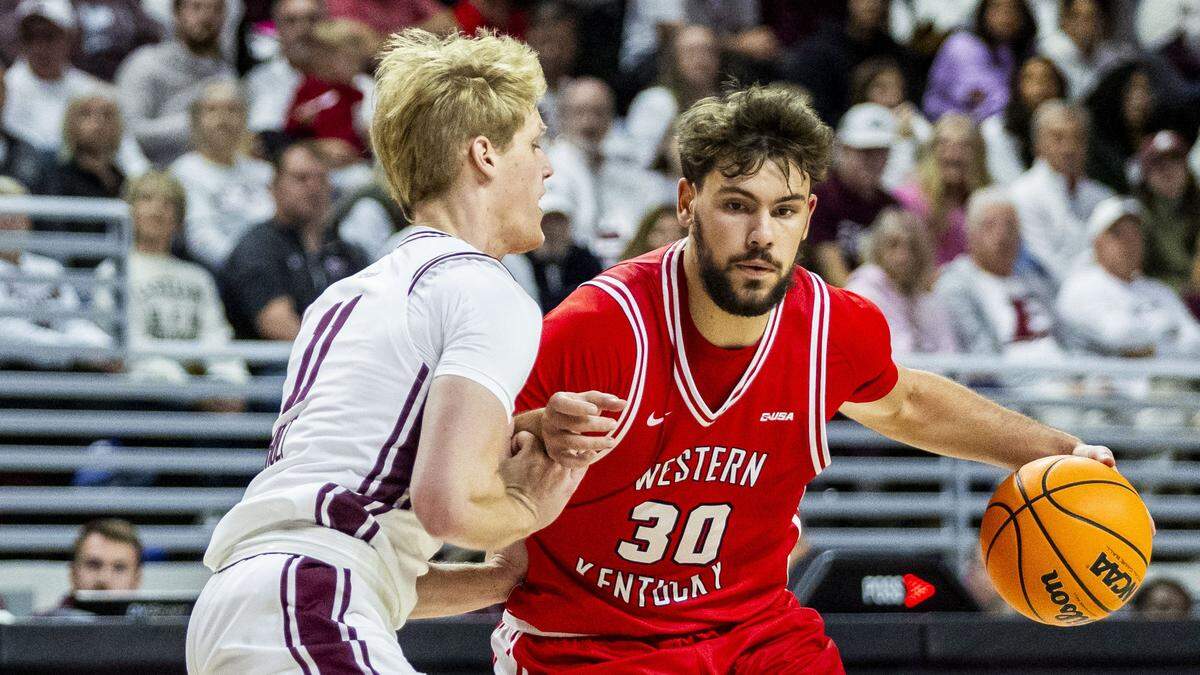 Western Kentucky basketball guard Teagan Moore (30) drives on Eastern Kentucky guard Jackson Holt (11) during WKU’s win Monday at Baptist Health Arena at Alumni Coliseum in Richmond.