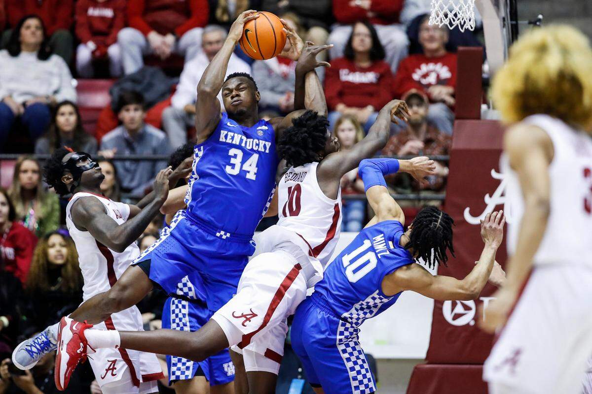 Kentucky Wildcats forward Oscar Tshiebwe (34) falls while grabbing a rebound from Alabama Crimson Tide center Charles Bediako (10) during the game at Coleman Coliseum in Tuscaloosa, Ky., Saturday, February 5, 2022.