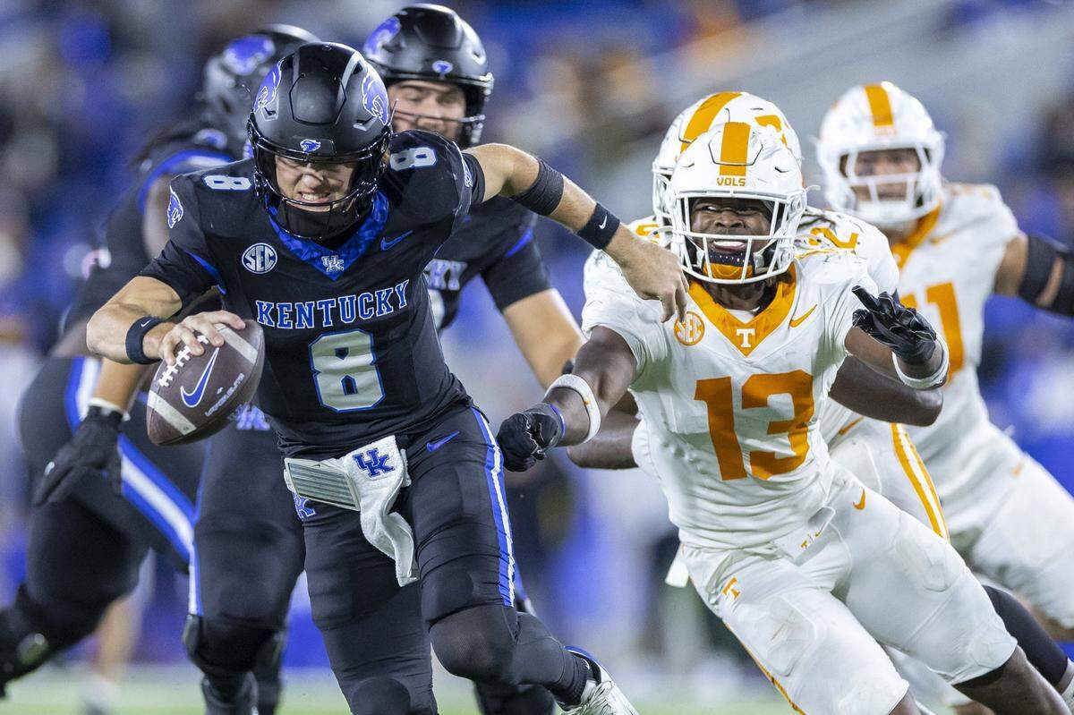 Kentucky quarterback Cutter Boley (8) is pressured by Tennessee linebacker Edwin Spillman (13) during Saturday’s game at Kroger Field.