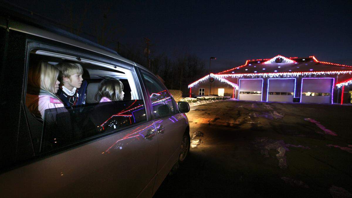The Dilgers — including siblings Claire, 10, left, Joseph, 8, and Grace, 6, — checked out the light display at Fire Station 20 at Harrodsburg Road and Arrowhead Drive last week. The display has grown each year since it started in 2006. To save energy, firefighters mostly use LED lights.    