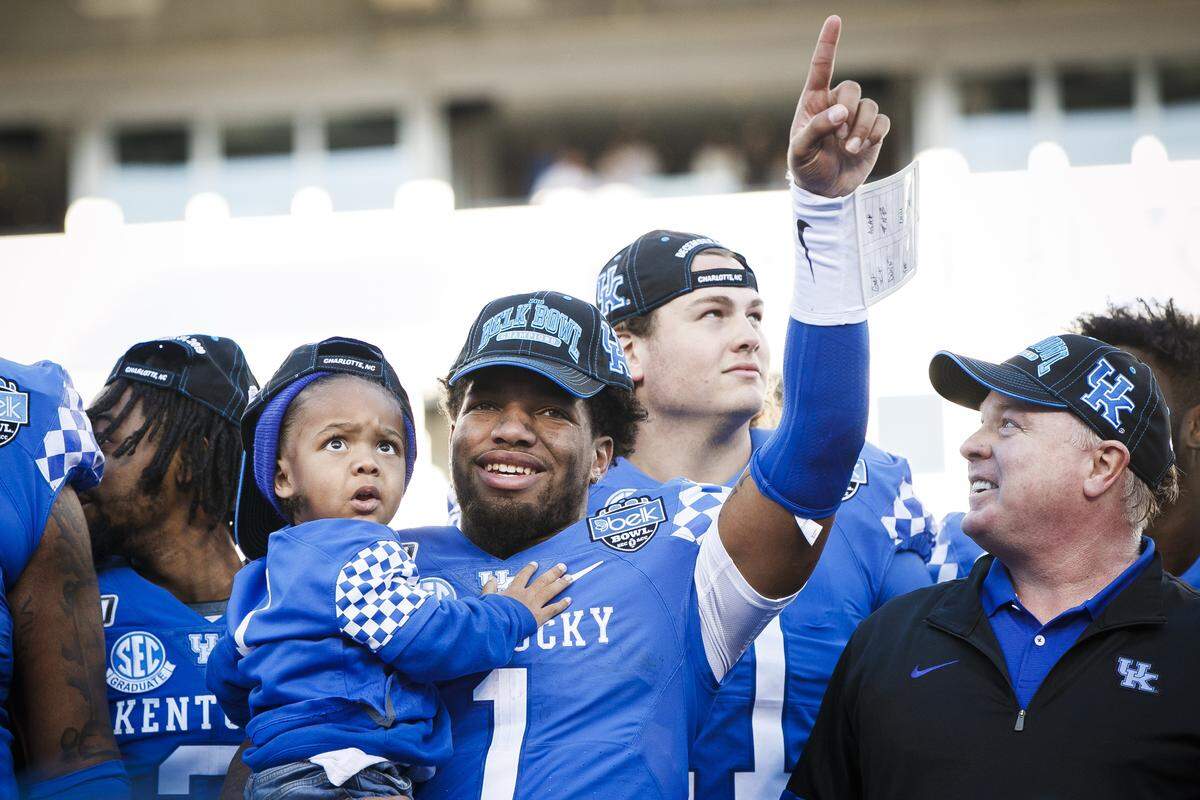 Kentucky star Lynn Bowden (1) celebrated with UK Coach Mark Stoops after leading the Wildcats to victory in the 2019 Belk Bowl with a 37-30, come-from-behind victory over Virginia Tech.