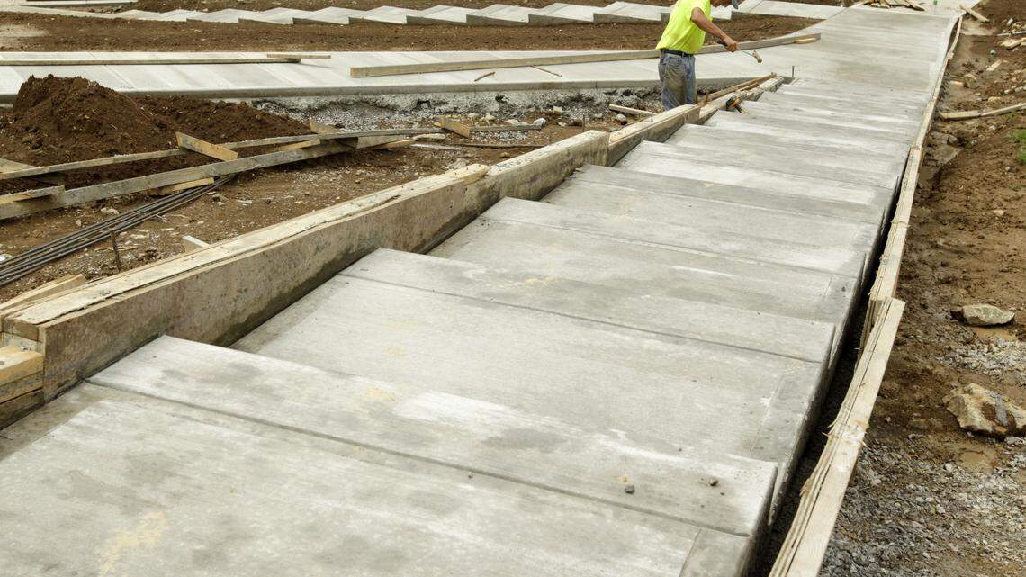 Gary Webb removed wooden molds Monday from a concrete staircase and ramp linking Millcreek Elementary to a playground and outdoor classroom.