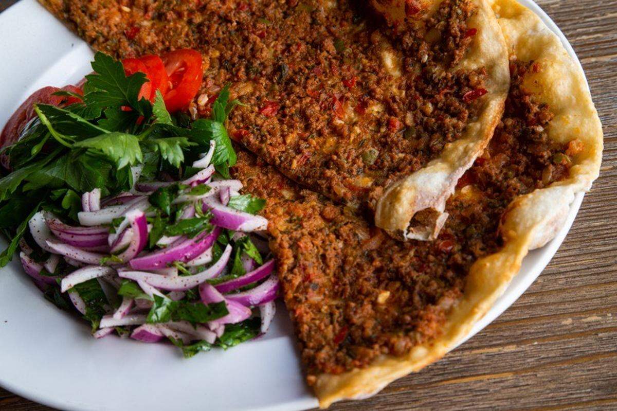 Lahmacun, a traditional Turkish fast food, is served dressed up at The Bridge Eatery & Bar in Lexington. The dish, though it resembles a pizza, is Turkish flatbread with ground beef and a few vegetables and herbs spread on top.