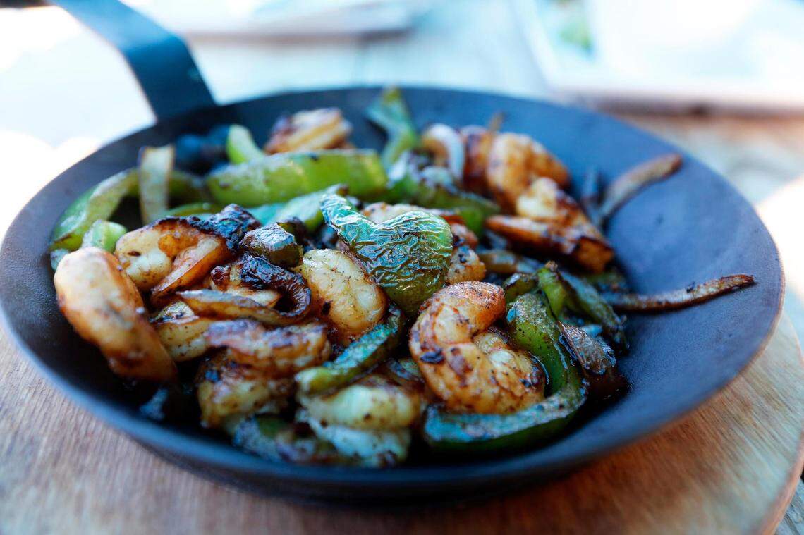 Shrimp fajitas at El Cid, June 23, 2021. The fajitas are served with a side of black beans, pico de gallo, tomatillo hot sauce and tortillas.
