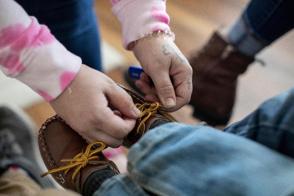 Megan Simpson helps her son Sawyer, 2, with his shoe laces before heading to the playground in Barbourville, Ky., Friday, May 7, 2021. Being there for her kids is one of Megan’s main motivations to get clean and move past addiction. Currently, Megan’s twin sister Morgan is caring for her three sons, but she is scheduled to get custody of them in Spring of 2022.