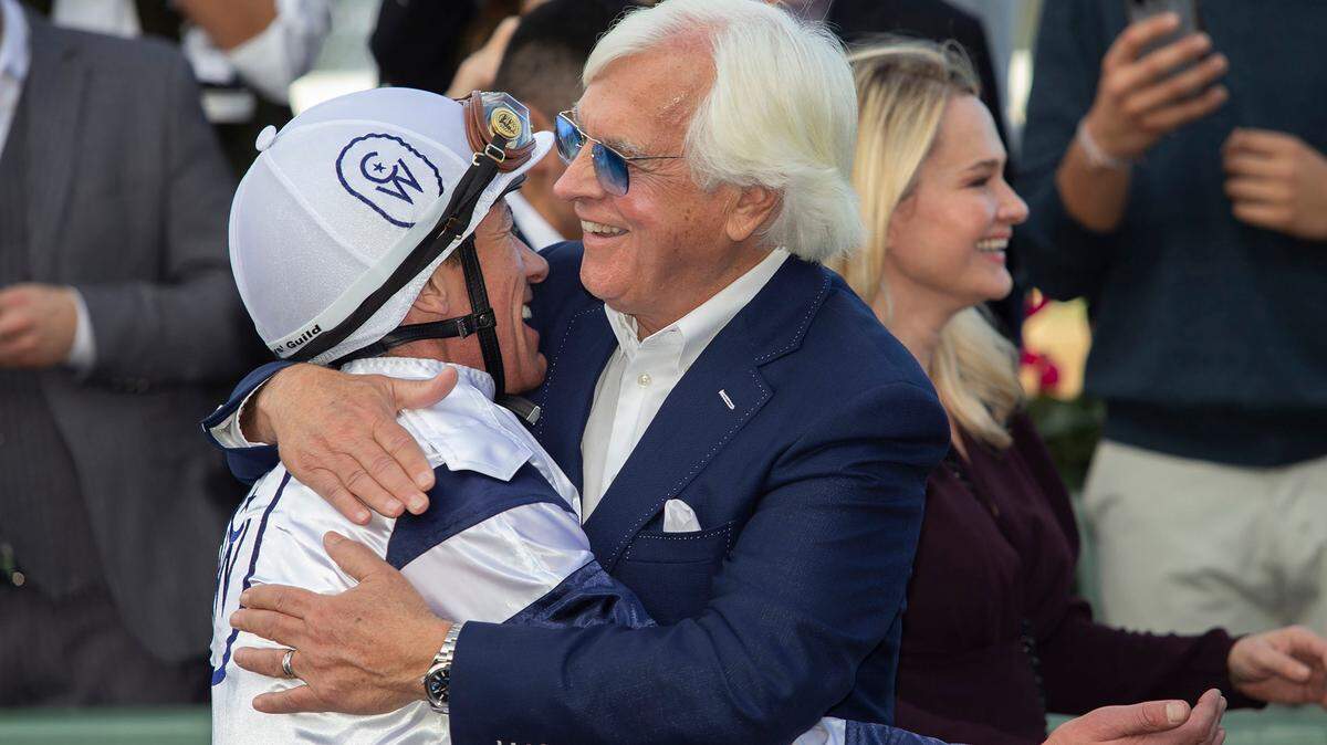 In this image provided by Benoit Photo, Country Grammar jockey Lanfranco Dettori, left, and trainer Bob Baffert, front right, celebrate after their victory in the Grade II $200,000 San Antonio Stakes horse race Monday, Dec. 26, 2022, on opening day at Santa Anita Park in Arcadia, Calif. (Benoit Photo via AP)