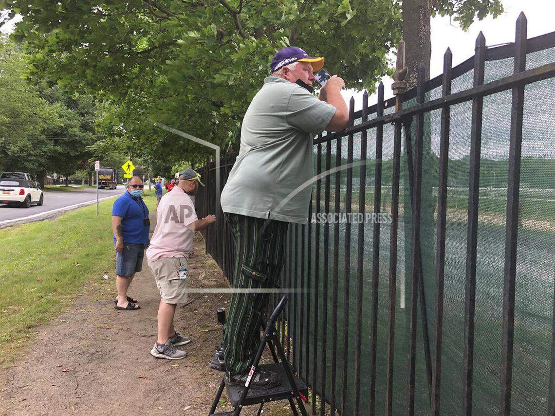 Horse racing fans tried to take in some of the action from outside the fence during Friday’s opening day of racing at Saratoga Race Course in Saratoga Springs, N.Y., on Friday. The track is running its traditional Summer Meet without spectators in attendance because of COVID-19.