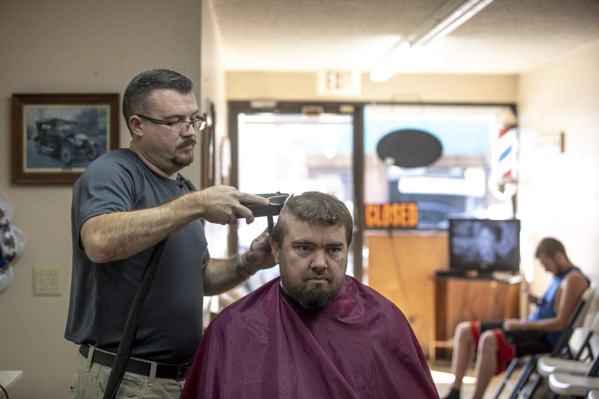 Matt Dixon gives William Ritchie a haircut at his barbershop in downtown Jackson Friday, Aug. 30. “It’s been the heart of the community for many years,” Dixon said about the Breathitt County football team.