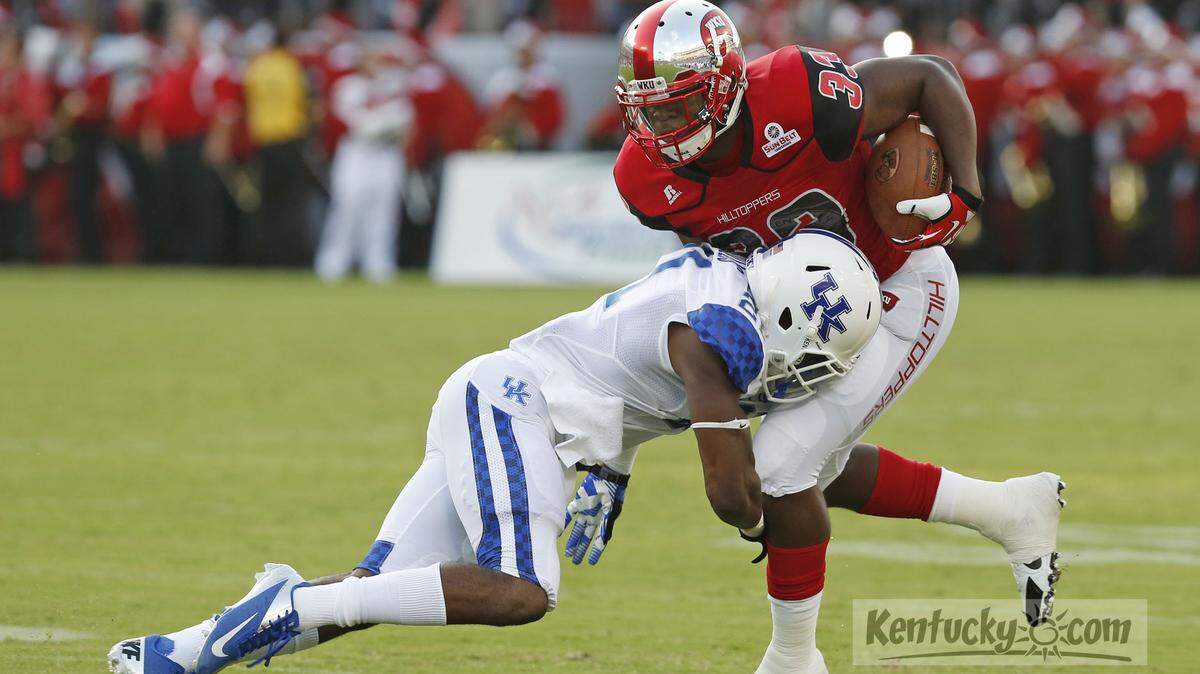 Kentucky Wildcats cornerback Rodney Cox (21) tackled Western Kentucky Hilltoppers running back Leon Allen (33) during the first quarter as UK played WKU at LP Field on Saturday, Aug. 31, 2013 in Nashville, Tenn. Photo by Amy Wallot