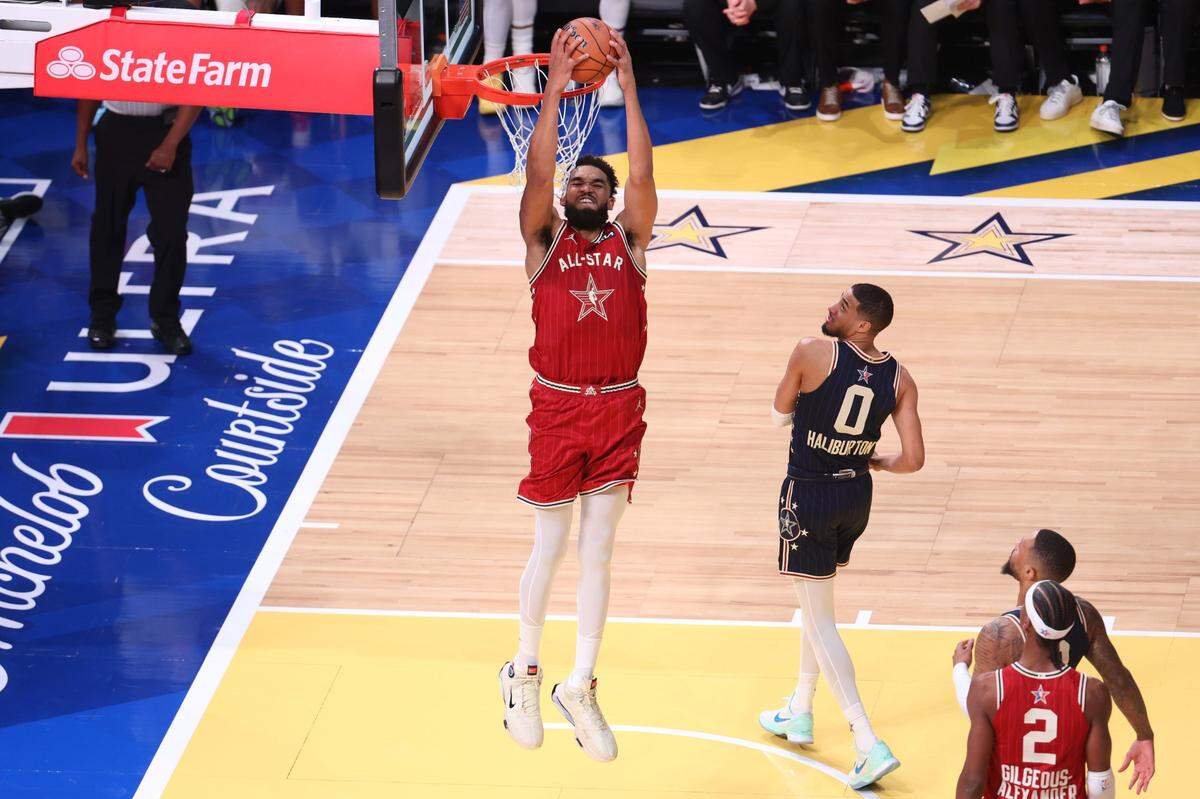 Feb 18, 2024; Indianapolis, Indiana, USA; Western Conference center Karl-Anthony Towns (32) of the Minnesota Timberwolves dunks the ball past Eastern Conference guard Tyrese Halliburton (0) of the Indiana Pacers during the fourth quarter in the 73rd NBA All Star game at Gainbridge Fieldhouse. Mandatory Credit: Trevor Ruszkowski-USA TODAY Sports