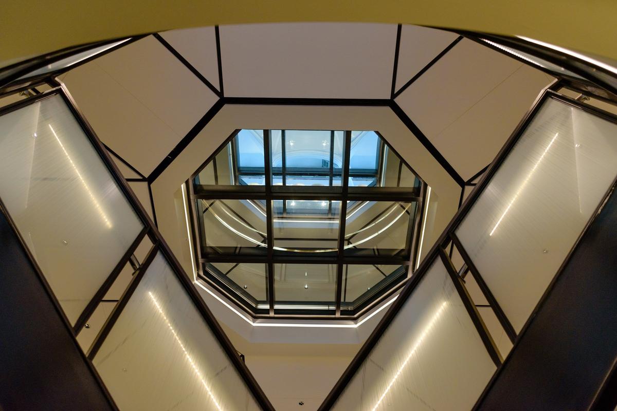 The ground floor of the former Fayette County courthouse where a split staircase leads up to the upper floors. A glass floor in the center of all the floors allows visitors to look all the way up to the dome.