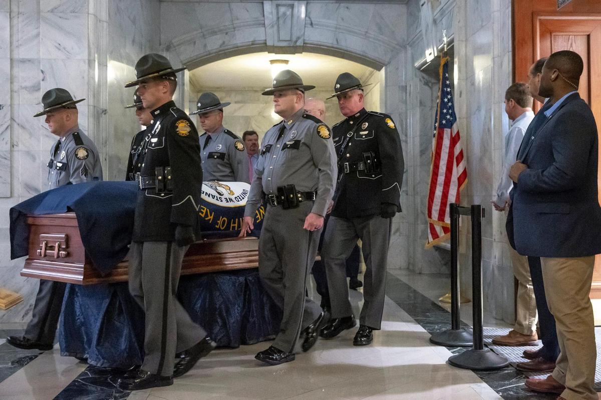 Kentucky Gov. Andy Beshear, third from right, watches as members of the Kentucky State Police Honor Guard bring the casket of former Kentucky governor John Y. Brown into the state Capitol in Frankfort, Ky., on Tuesday, Nov. 29, 2022. Brown, a Democrat, was the 55th Governor of the commonwealth, serving from December 1979 to December 1983. Brown lied in state in the Capitol rotunda on Tuesday.