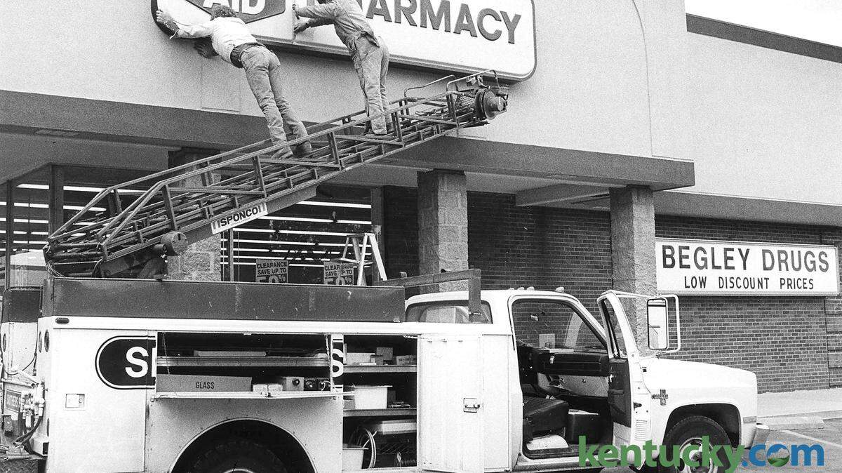 Red McDaniel and Paul Fletcher, employees of Smithers Sign Co., put up a new Rite Aid Pharmacy sign on  April 28, 1988, at the former Begley drugstore in Imperial Shopping Center on Waller Avenue in Lexington.