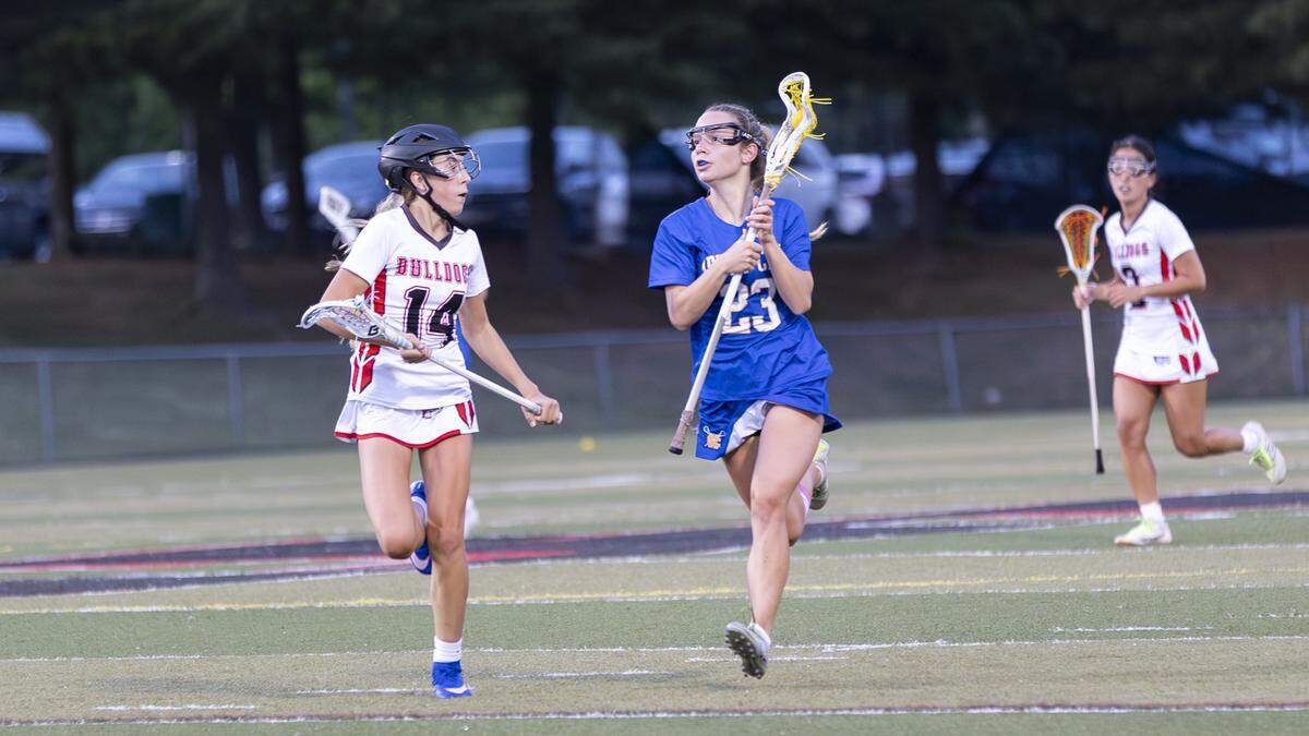 Henry Clay’s Vonnie Allen-Guy (23) advances the ball with Paul Laurence Dunbar’s Riley Sword (14) giving chase during the Blue Devils’ 10-3 win at Paul Laurence Dunbar High School on Monday.