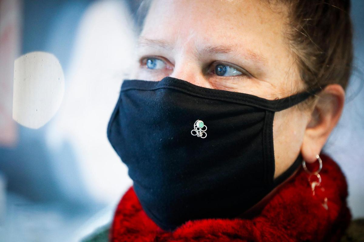 Rachel Savané, of Lexington, Ky., owner and jewelry designer at Savané Silver shows a one of her hand made mask pins in the gallery’s showroom in Lexington, Thursday, Dec. 17, 2020. The pins come in various designs and are built around aventurine and chrysoprase gemstones.