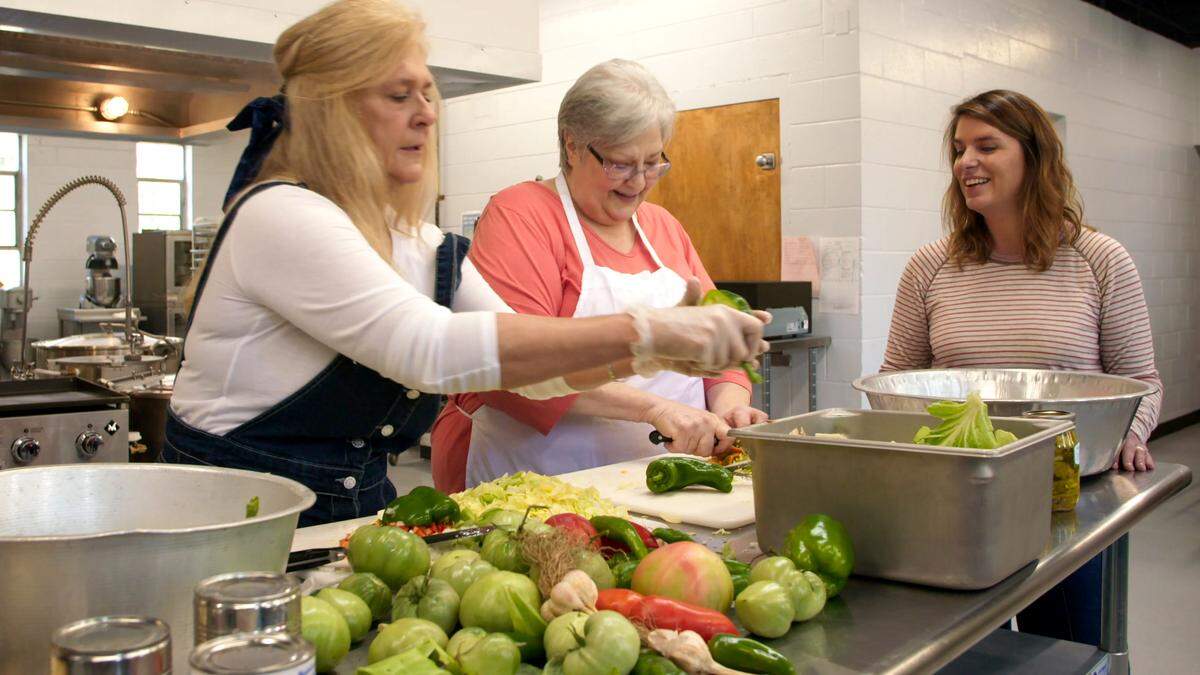 Regina Niece (left) and Carolyn Sturgill (center) show Vivian Howard how they make chow-chow at the CANE Kitchen in Whitesburg, Ky.