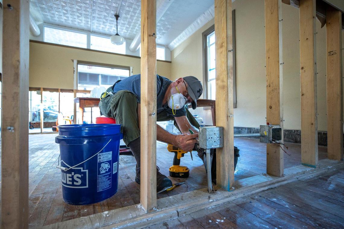 Mike Gilmer installs an electrical outlet at the Appalachian Citizens Law Center in Whitesburg, Ky., on Thursday, Aug. 4, 2022, after it was damaged by a flash flood last week.