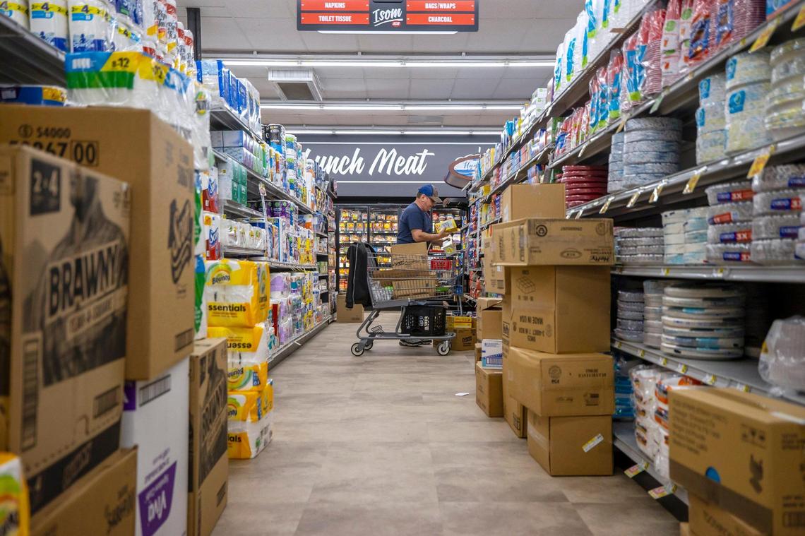 Dale Blair, who has worked at the Isom IGA for 41 years, stocks shelves Thursday as the store prepares to re-open.