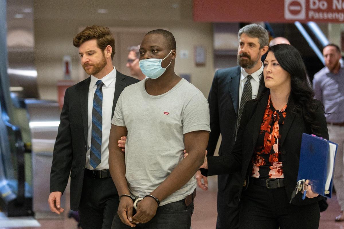 Adedunmole Gbadegesin, a suspect for a fraud case, is walked through Blue Grass Airport by FBI agents to an awaiting SUV after being extradited from Nigeria, April 27, 2022.