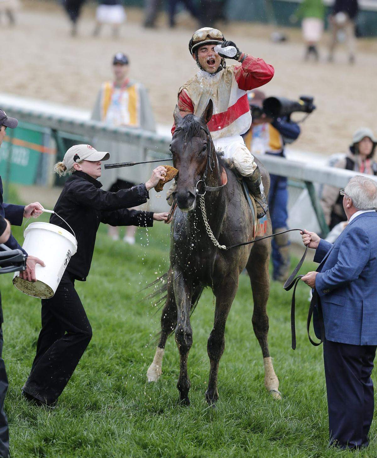 Orb received a bath while jockey Joel Rosario took a drink of water after winning the 2013 Kentucky Derby.