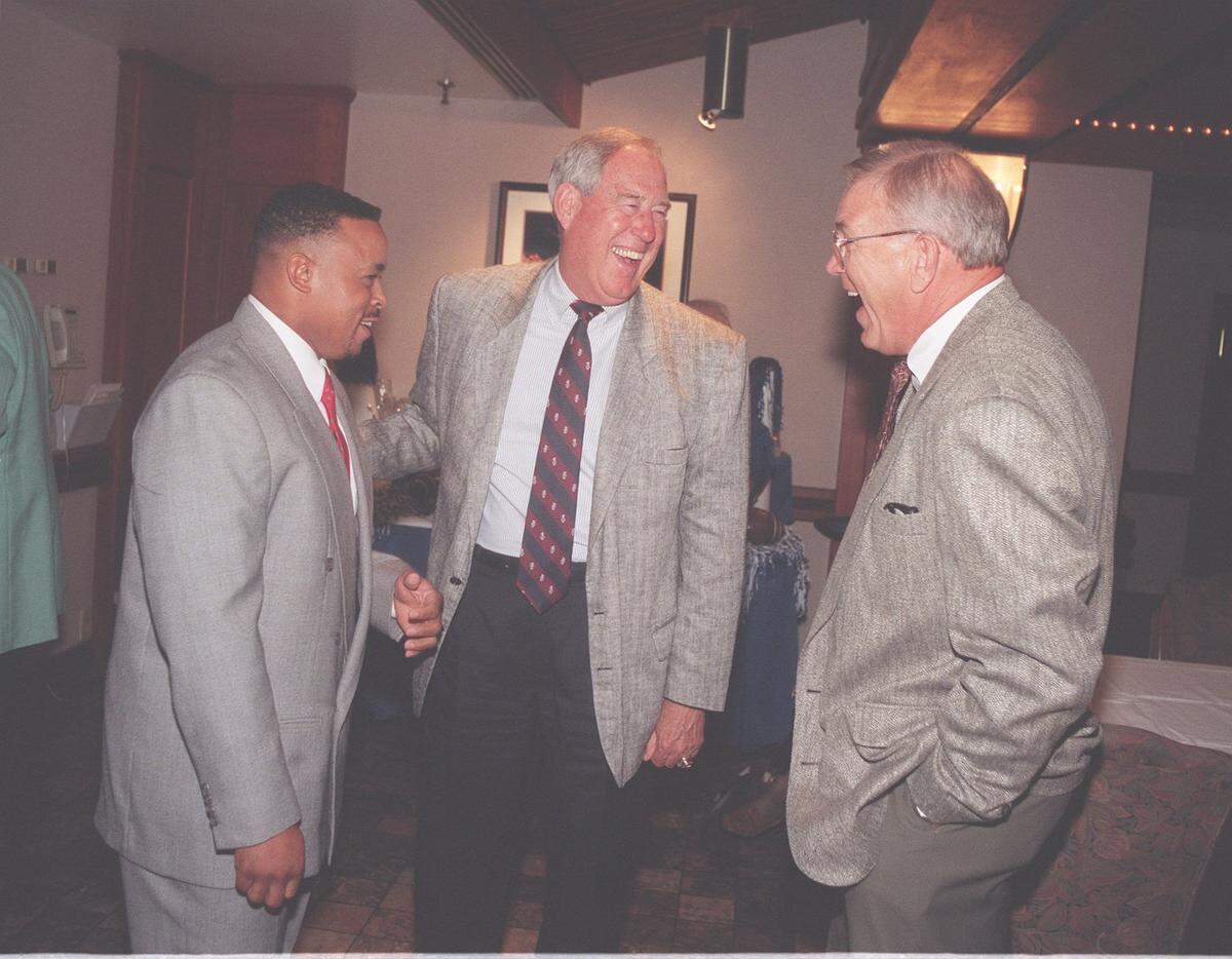 Mark Higgs, left, chatted with then-Kentucky Athletics Director C.M. Newton, center, and ex-UK football player Calvin Bird in 1997 when Kentucky retired the jerseys of both Higgs and Bird.
