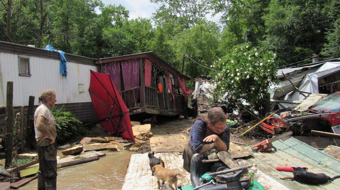 Joe Salley Jr., left, and Kayla Brown worked on a lawnmower amid the debris of their mobile home wrecked by a flood in the  Grapevine community of Perry County on July 28, 2022. Brown fell during the flood while trying to escape and clung to a tree until she was rescued.