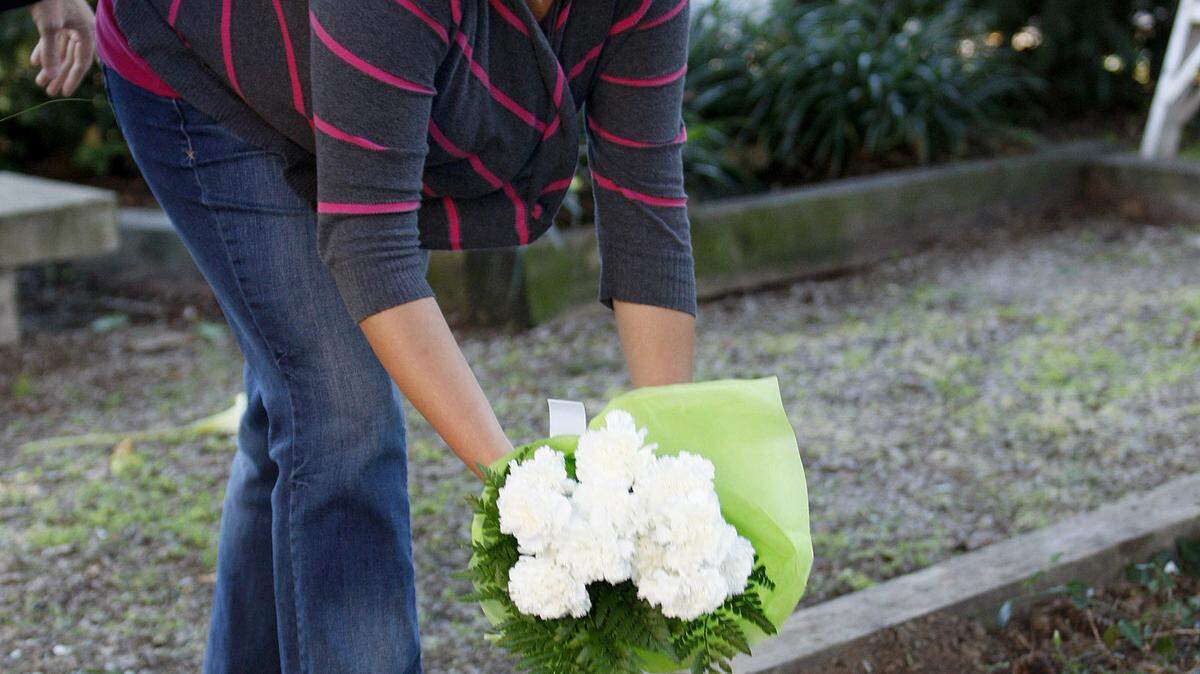 Brandy Durman places a bouquet of flowers at the memorial honoring her late husband Officer Bryan Durman, who was killed in the line of duty in April 2010, at its dedication at Founders Park in Lexington, Ky., Monday, October 3, 2011. Photo by Matt Goins 12741