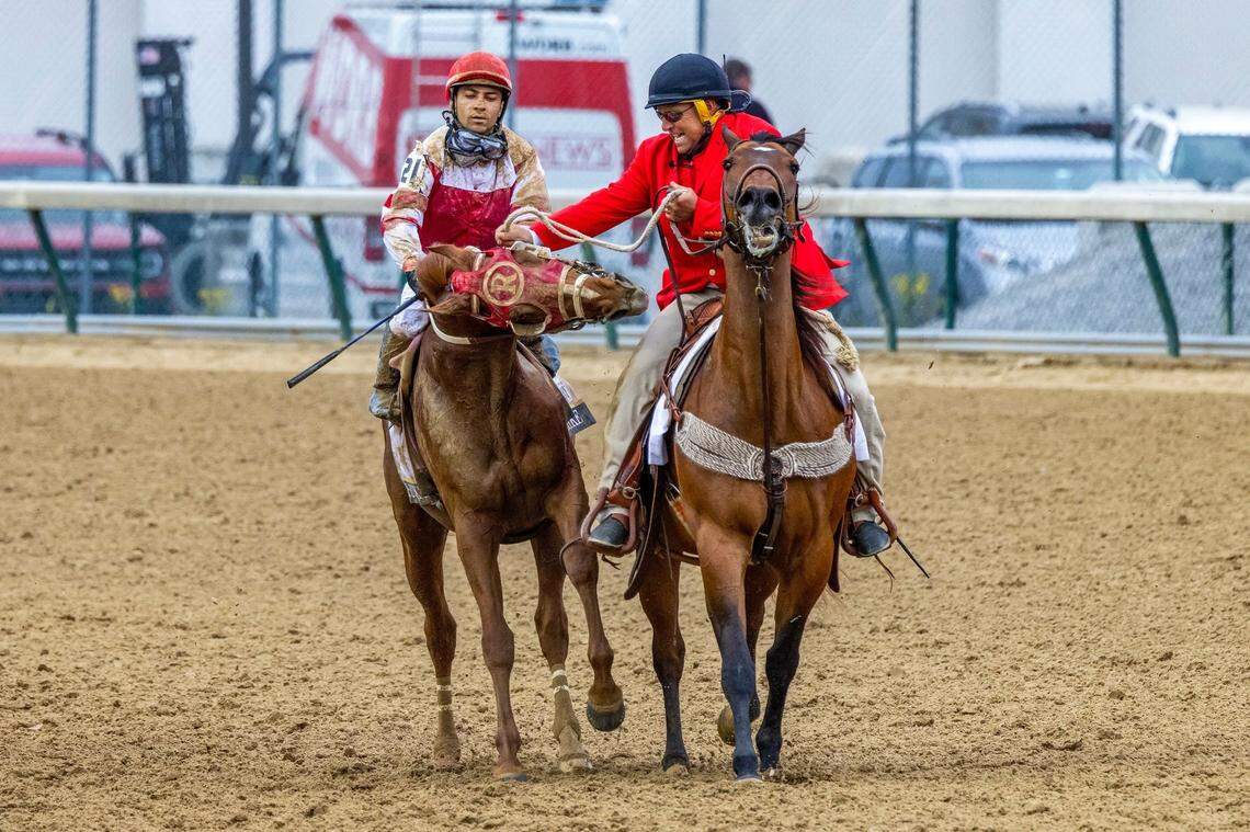 An excited Rich Strike, left, nipped at the leg of outrider Greg Blasi and his track pony as they guided him to the winner’s circle at Churchill Downs in Louisville, Ky., Saturday May 7, 2022 after Rich Strike won the 148th Kentucky Derby.