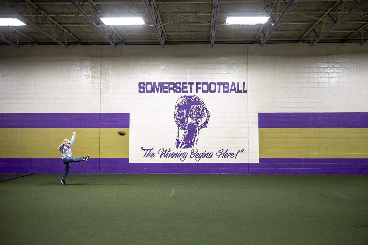 Anikan Johnson, grandson of Max Messamore, a Somerset quarterback in 70s and current middle school coach, kicks a football in the Somerset field house prior to Friday’s game.
