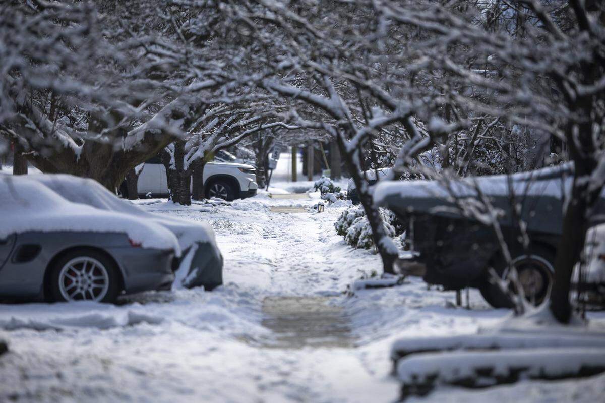Snow covers a sidewalk in Lexington, Ky., Friday, Dec. 12, 2025.