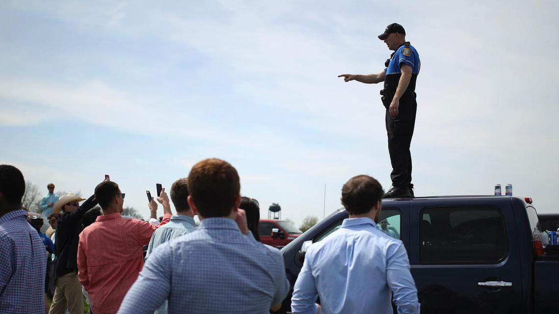 A police officer stood on a truck to talk to a crowd after a disorder in the tailgating area at Keeneland Saturday.