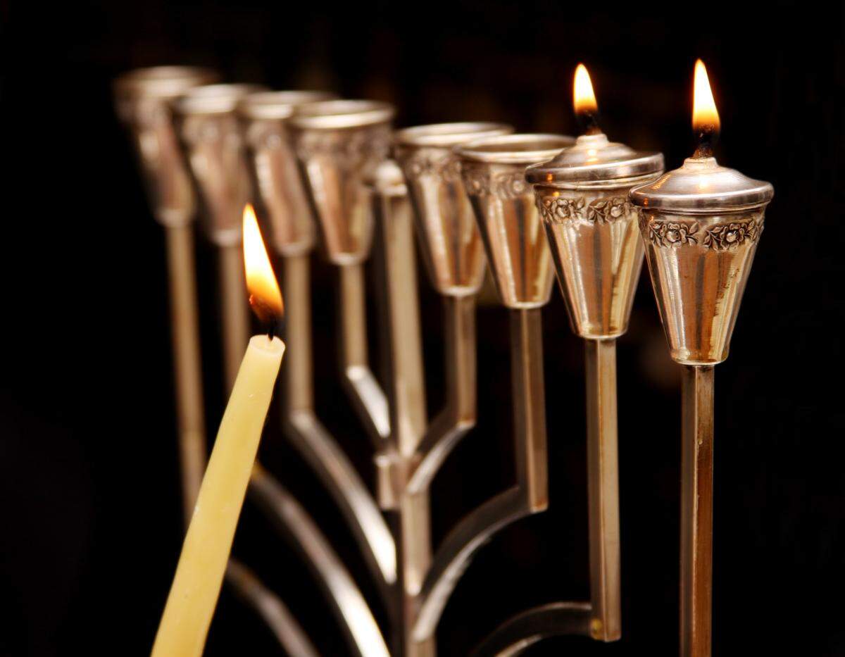 Lighting a menorah for Hanukkah, which begins Dec. 10. Temple Judea in Coral Gables has planned eight days of activities to celebrate Hanukkah, entitled “Mitzvah, Miracles and Munchies.”