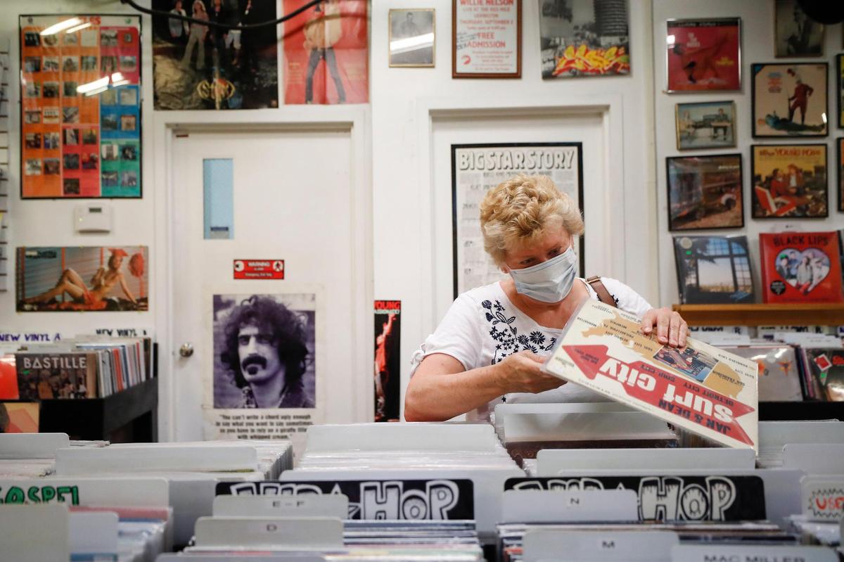 Melanie Smith looks through stacks of records June 11 at Lexington’s CD Central. According to owner Steve Baron, there has been a large resurgence of vinyl records over the past decade and the store sells more records than CDs.