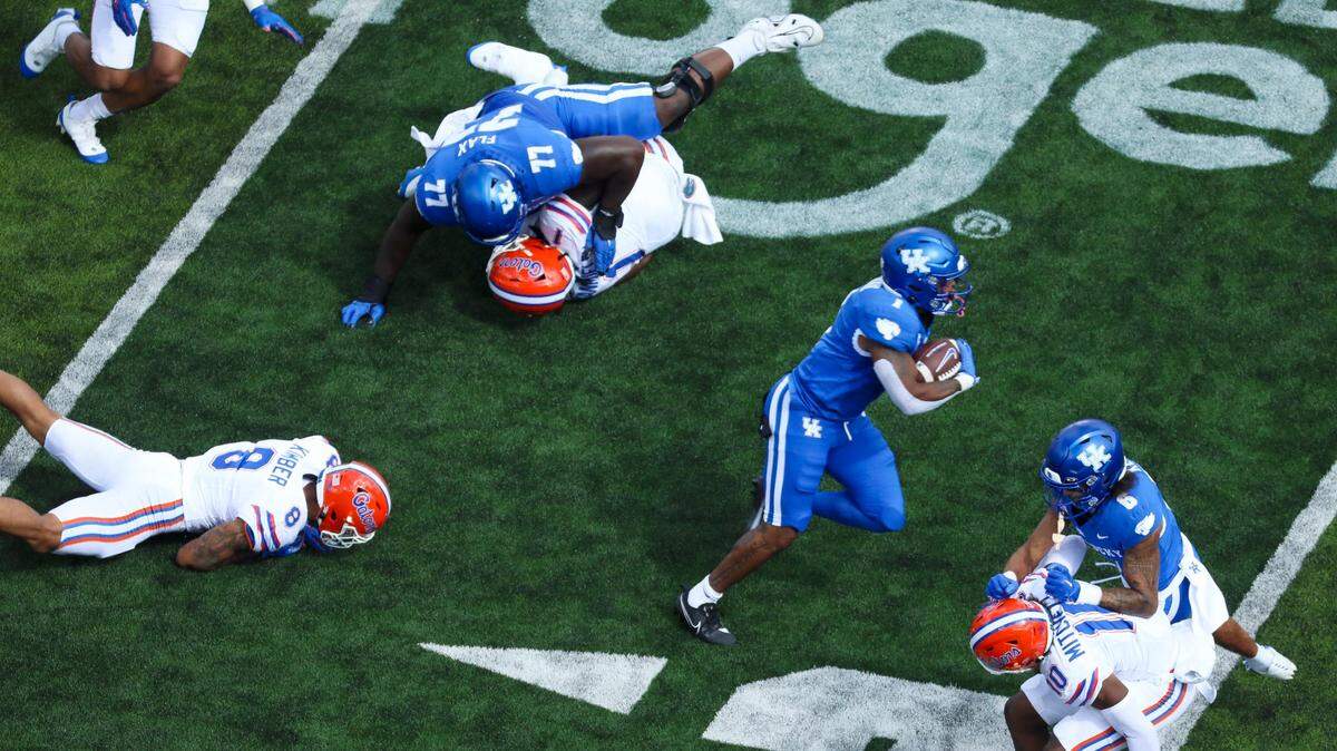 Kentucky running back Ray Davis (1) runs behind the blocking of offensive lineman Jeremy Flax (77) and wide receiver Dane Key (6) during Saturday’s game against Florida at Kroger Field.