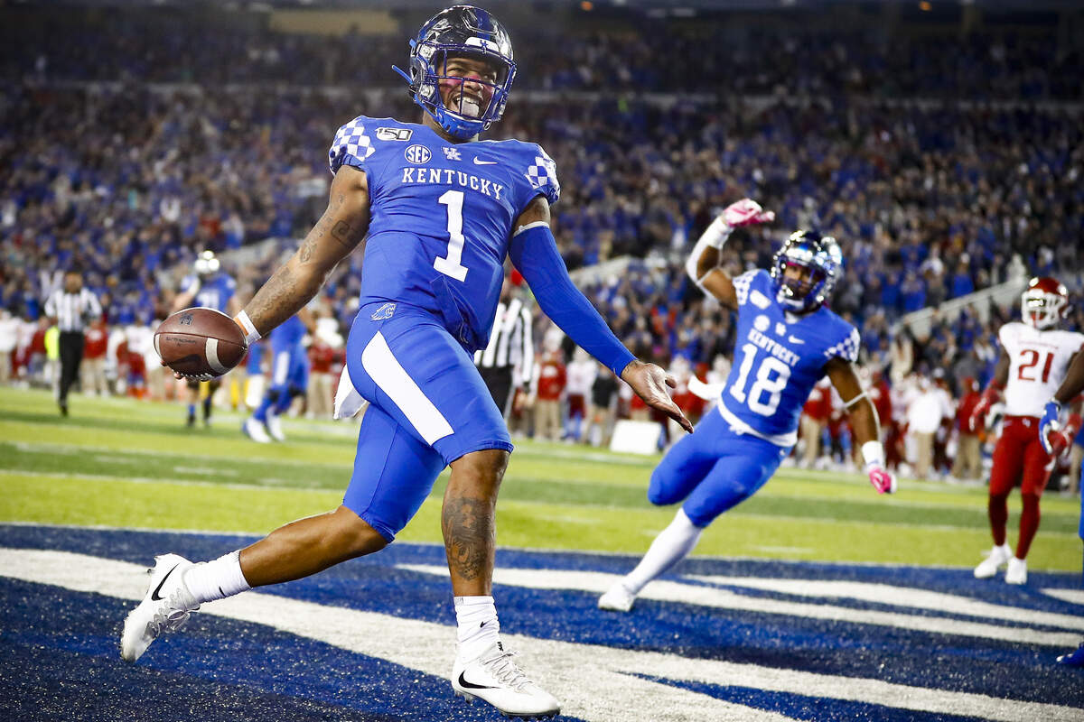 Kentucky Wildcats quarterback Lynn Bowden Jr. (1) celebrates a touchdown past Arkansas Razorbacks defenders in the fourth quarter of their game at Kroger Field in Lexington, Ky., Saturday, Oct. 12, 2019.