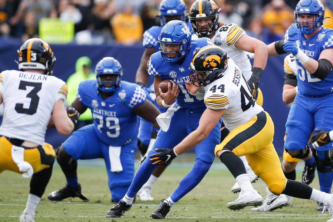 Kentucky quarterback Destin Wade gains 3 yards before being tackled by Iowa’s Seth Benson during the Music City Bowl in Nashville.