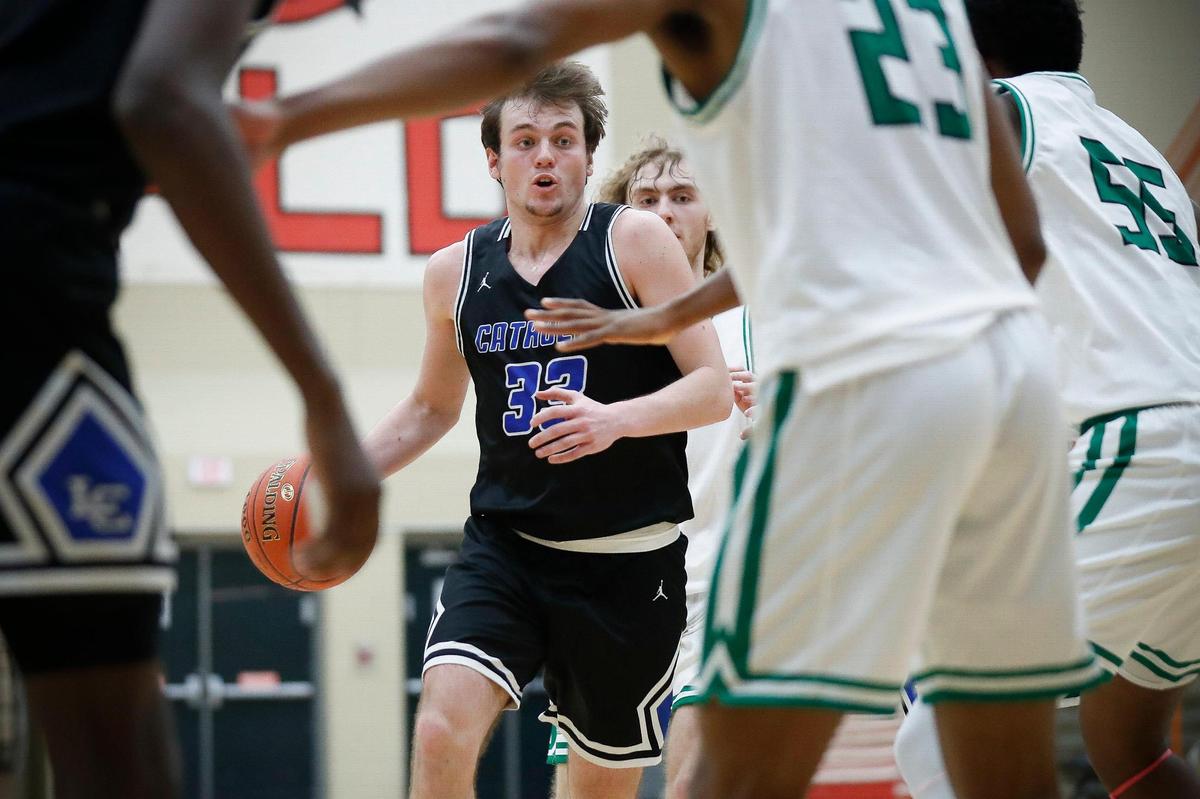 Lexington Catholic’s Ben Johnson (33) dribbled between Paul Laurence Dunbar defenders during Thursday’s game at Dunbar. The Knights won 69-67.
