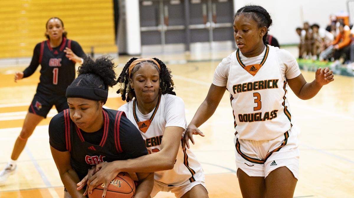 Frederick Douglass’ Jaelee Knowles, center, tied up a ball possessed by George Rogers Clark’s Annette Miller as Broncos’ teammate Eiona Atkins (3) came to help during the second half of the Douglass Holiday Showcase at The Farm on Saturday.