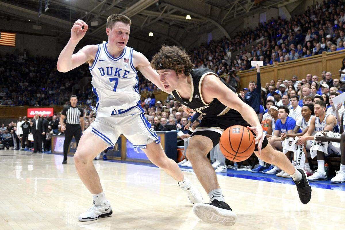 Nov 16, 2024; Durham, North Carolina, USA; Wofford Terriers guard Jackson Sivills (0) drives the ball down the baseline while Duke Blue Devils guard Kon Knueppel (7) guards during the first half at Cameron Indoor Stadium. Mandatory Credit: Zachary Taft-Imagn Images