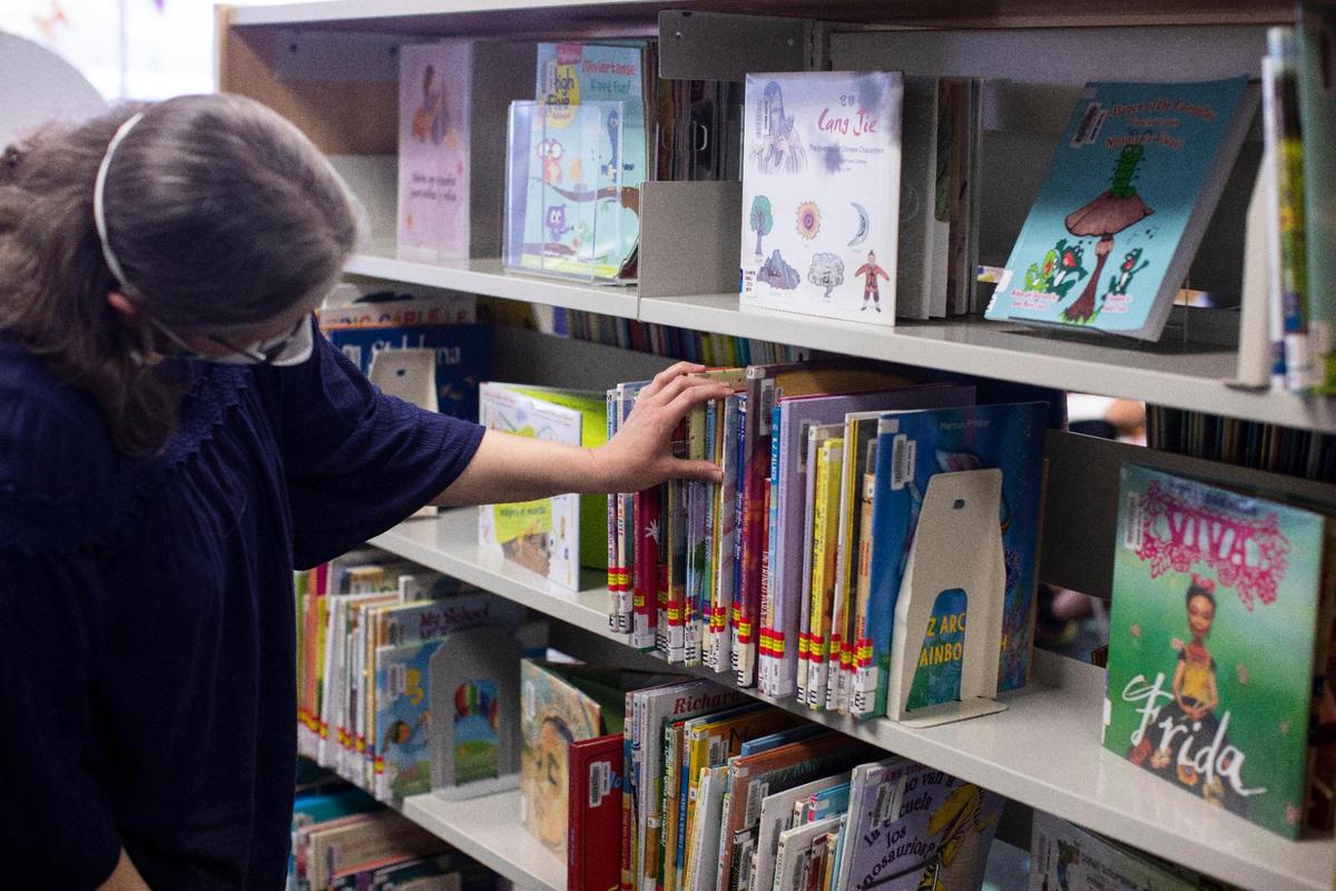 Mary Landrum, a children’s librarian at the Lexington Public Library and chair of the Intellectual Freedom Committee of the Kentucky Public Library Association, replaces books at the Village Branch of the Lexington Public Library in Lexington, Ky., Thursday, April 28, 2022.