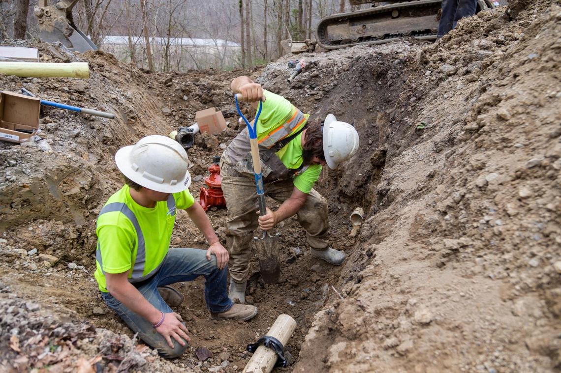 Dillon Fluegge and Brenden Wilkens work to repair a water main along a road outside Inez in Martin County, Ky., Wednesday, March 17, 2021. 