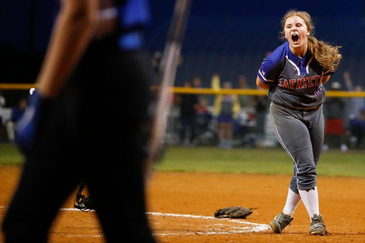 Lafayette pitcher Trinity Bridges (14) celebrates after striking out Lexington Catholic’s Caitlyn Kelley (77) to end the 11th Region finals.