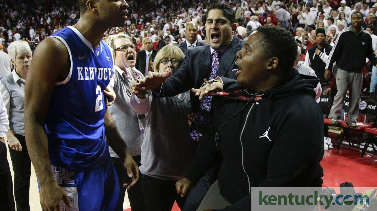 Kentucky freshman guard Aaron Harrison and an Arkansas fan argued after Tuesday's game and had to be separated by UK assistant coach Orlando Antigua, center. Arkansas defeated No. 13 Kentucky 87-85 in overtime in Fayetteville, Ark.