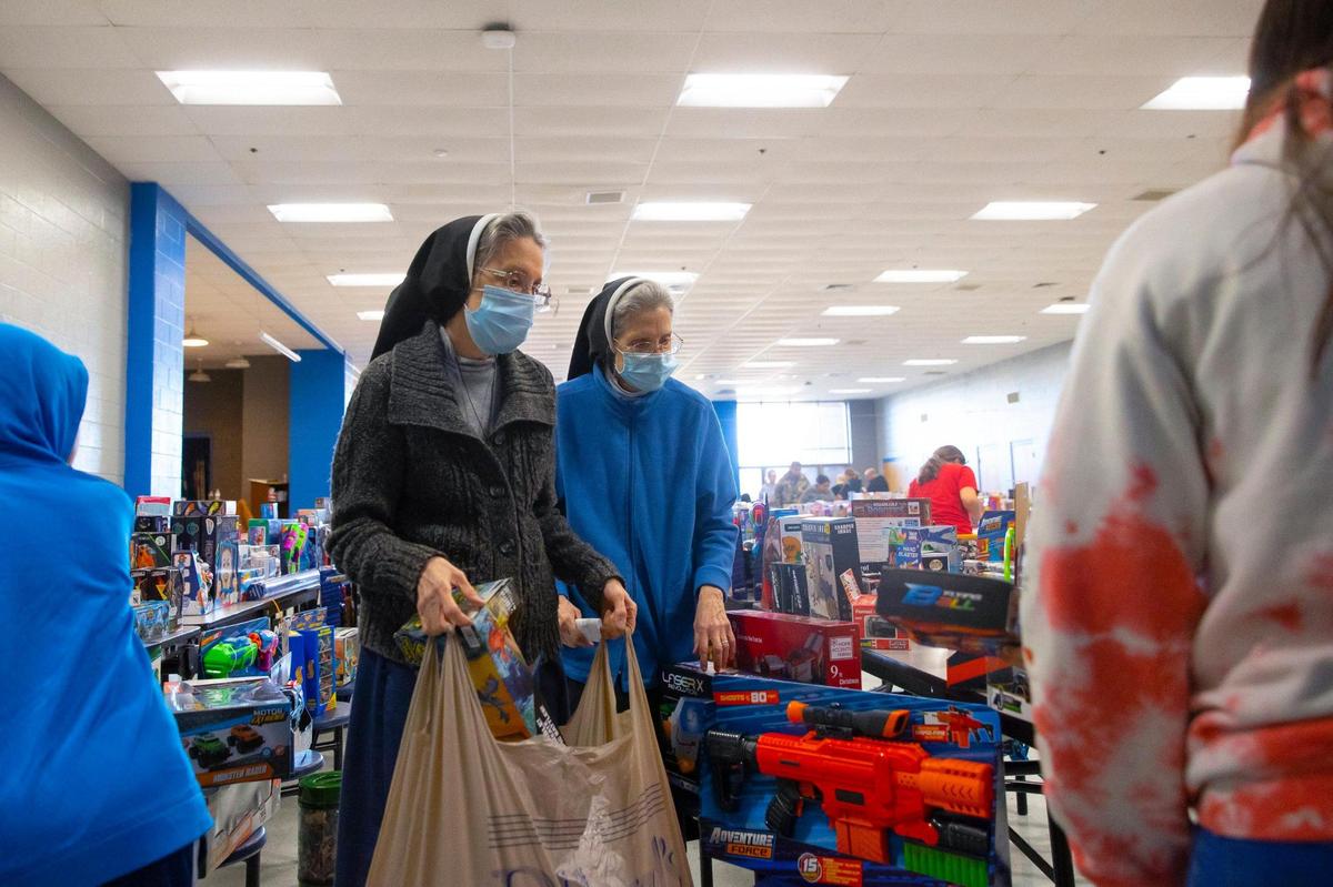 Sister Maria Francine, left, a Sister of Notre Dame in Covington who teaches at Notre Dame Academy with her sister, Sister Anita Marie, help families select presents at Graves County Middle School in Mayfield, Ky., on Monday, Dec. 20, 2021, during the distribution of Christmas gifts donated for students affected by the deadly tornado that ripped through the county earlier in December.