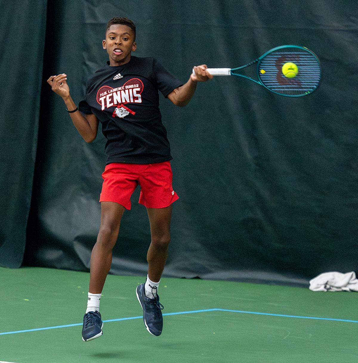 Paul Laurence Dunbar’s Evan Fomby returns a shot Friday in his singles win against Lafayette’s Charlie Mooney in the 11th Region championships.