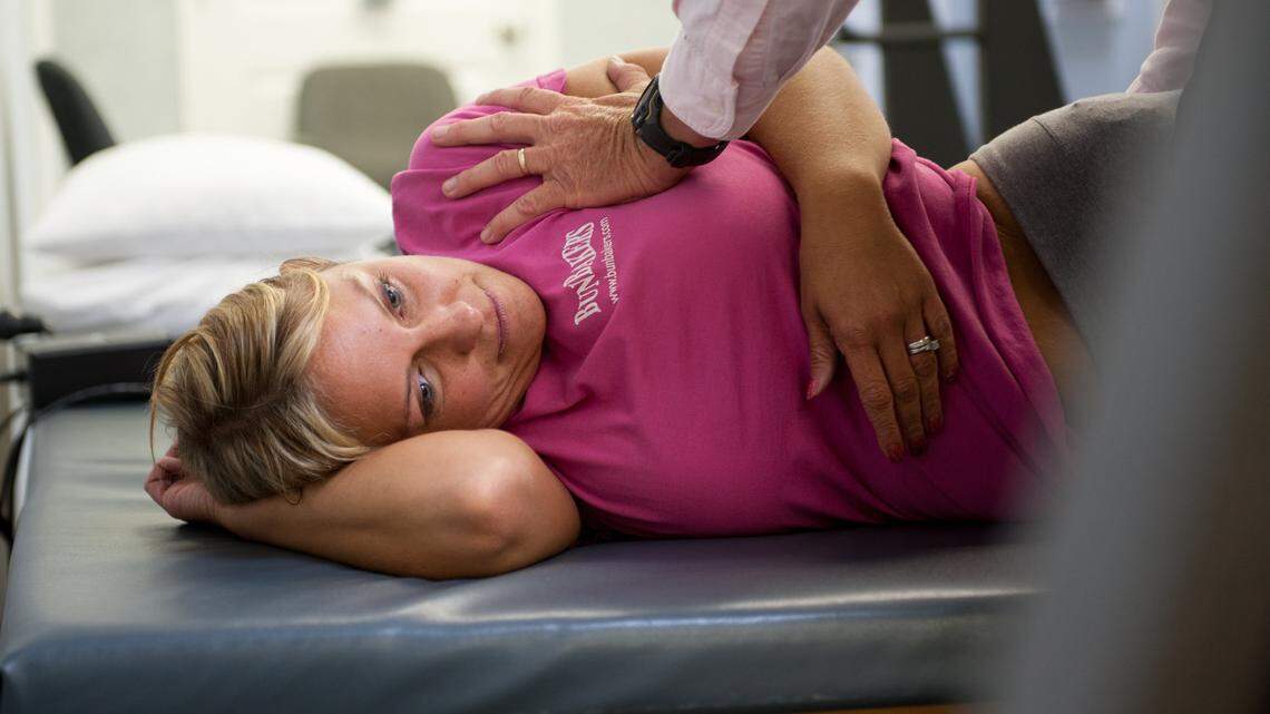 Missy Jenkins Smith worked with Dr. Scott Winkler during a physical therapy session at Physical Medical Services in Murray on July 30. Jenkins Smith was paralyzed from the chest down in the 1997 Heath High School shootings that killed three of her classmates.