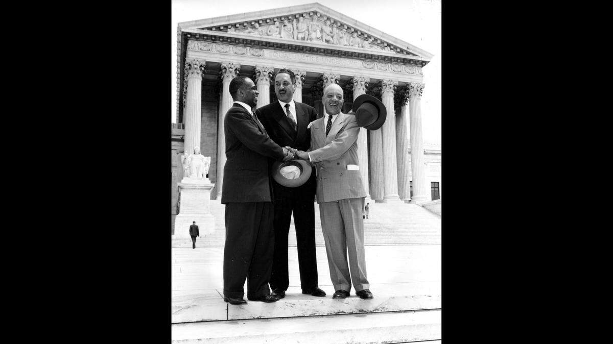 In this May 17, 1954 photo, George E.C. Hayes, left, Thurgood Marshall, center, and James M. Nabrit join hands outside the U.S. Supreme Court in Washington, D.C., after justices declared in the Brown v. Board of Education decision that separate but equal schools for black children were unconstitutional.